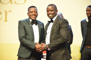 Outgoing executive chairman Simeon Bulezi shakes hands with incoming Chairman  Kennedy Mpanga